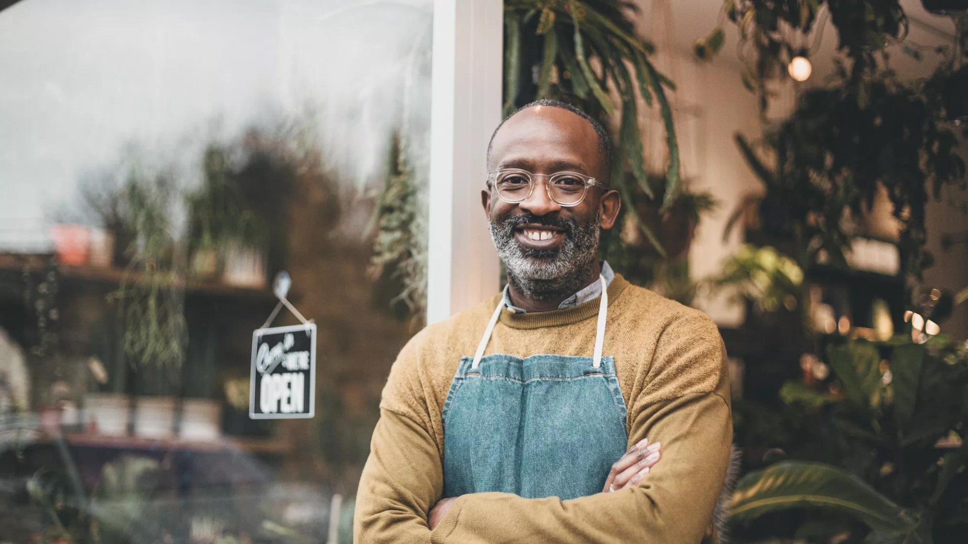 Man smiling in front of his small business.