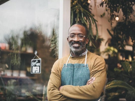Man smiling in front of his small business.